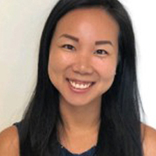 Teresa has long hair, is wearing a sleeveless shirt and smiling.